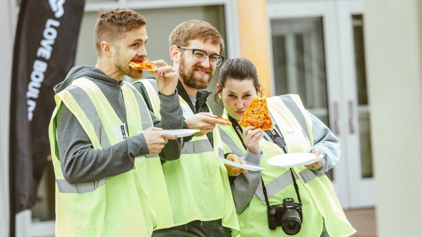 Love Boulder volunteers in safety vests grabbing slices of pizza